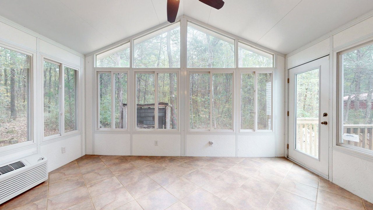 Inside the sunroom, looking out into the woods
